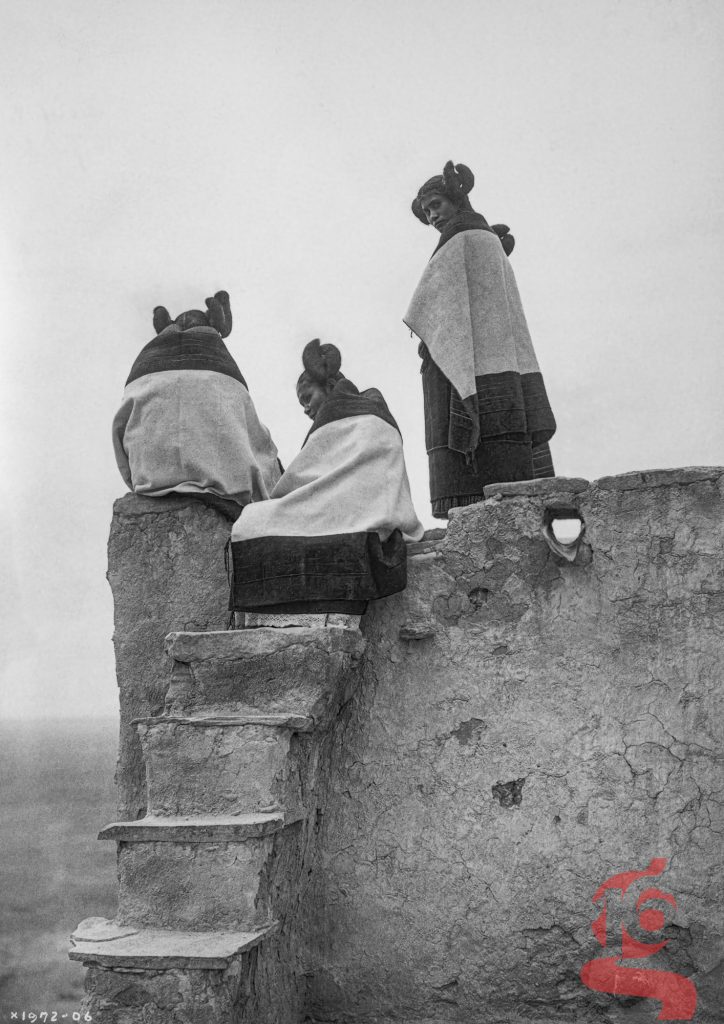 Trois femmes hopi au sommet de marches en adobe photographiées par Edward S. Curtis en 1906