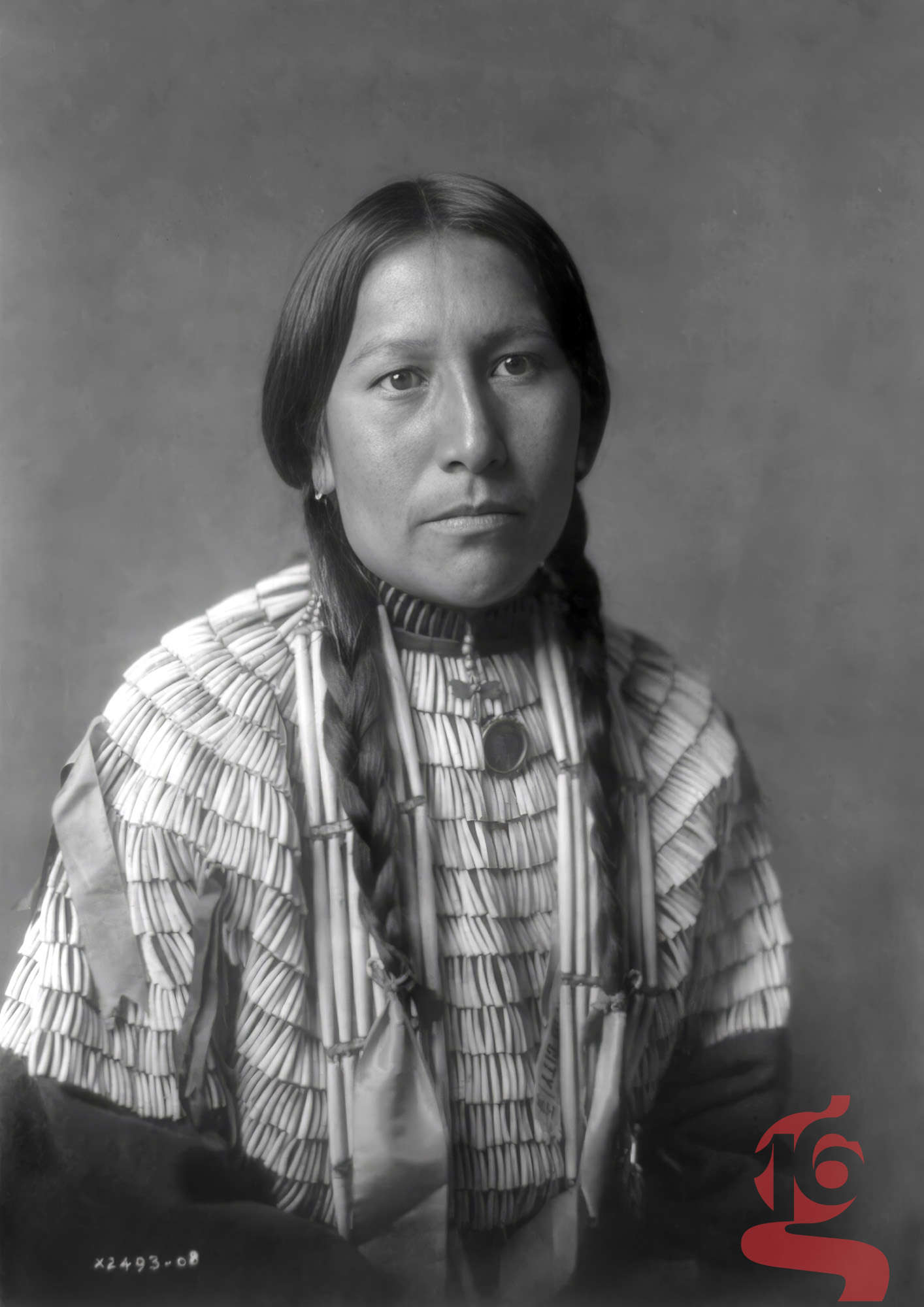 Portrait de la fille d’American Horse, jeune femme lakota aux longues tresses et vêtement orné, photographiée par Edward S. Curtis en 1908