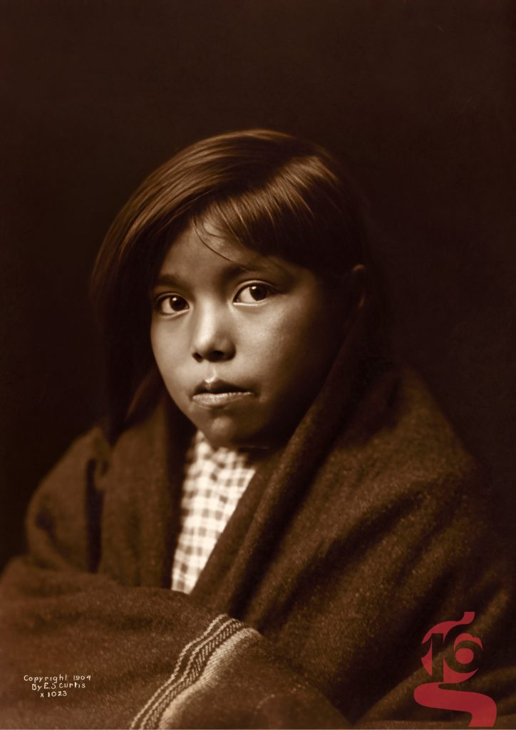 Portrait d’une jeune fille diné Navajo enveloppée dans une couverture, photographiée par Edward S. Curtis en 1904