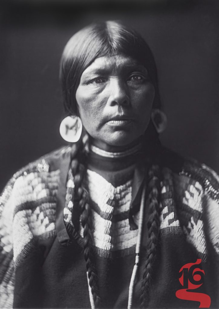 Portrait frontal de l’épouse d’Ow High, femme piegan photographiée par Edward S. Curtis vers 1905.