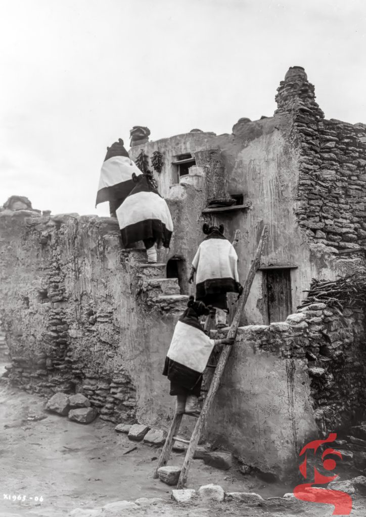 Quatre jeunes femmes hopies gravissant les échelles et les terrasses du pueblo de Walpi, photographiées par Edward S. Curtis en 1906.