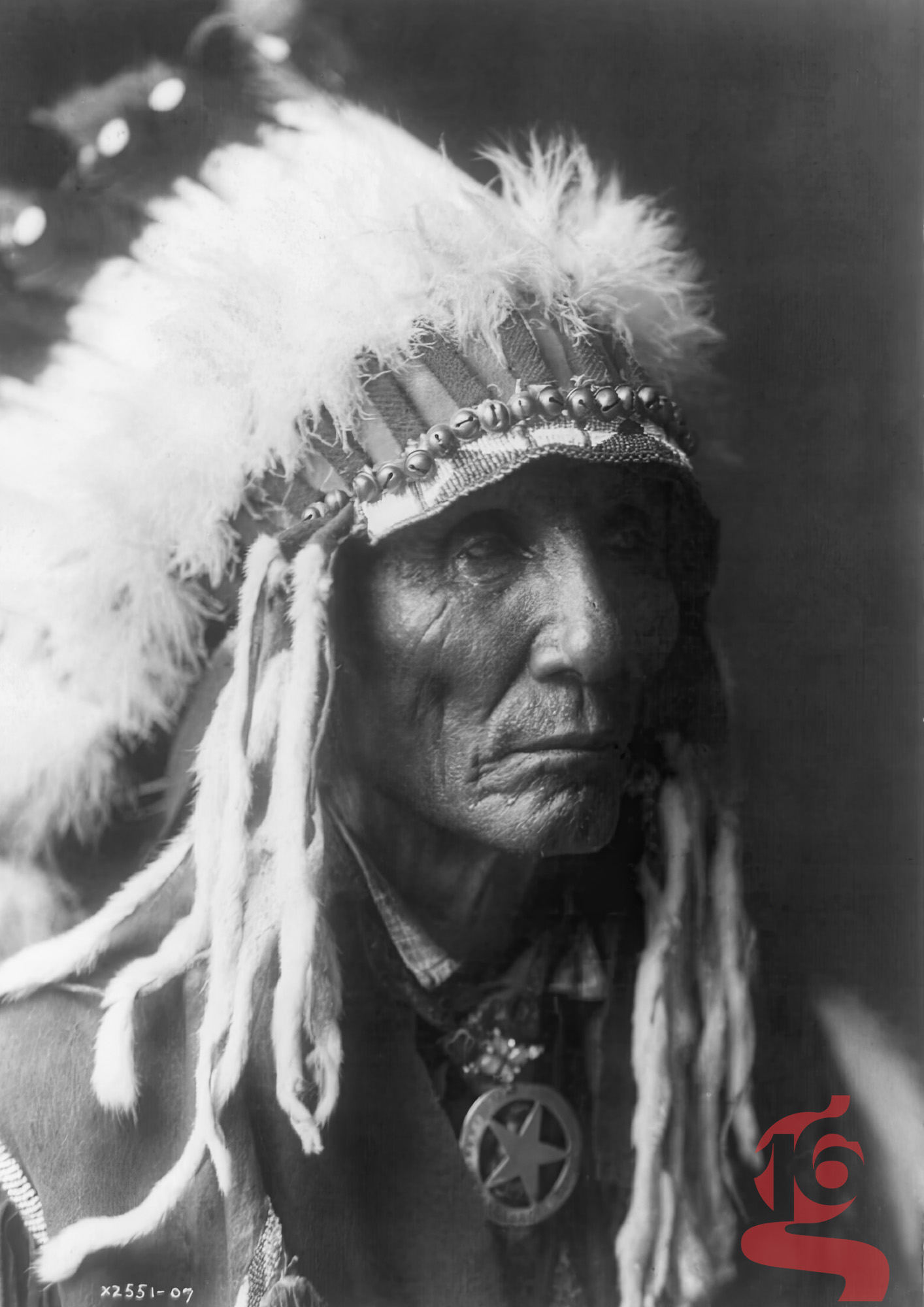 Calico, homme Oglala Lakota portant une coiffe de plumes, portrait par Edward S. Curtis
