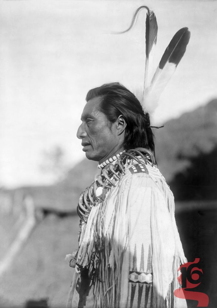 Crow’s Heart, homme Mandan de profil portant deux plumes et un collier de griffes d’ours, Edward S. Curtis, 1908