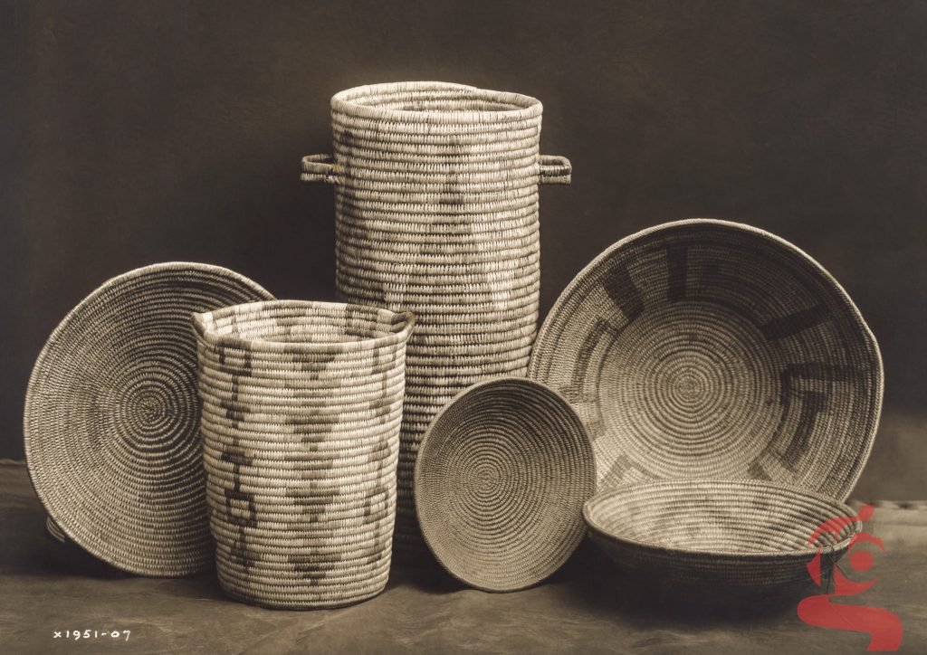 Assortiment de paniers et récipients en vannerie apache photographié par Edward S. Curtis en 1907.