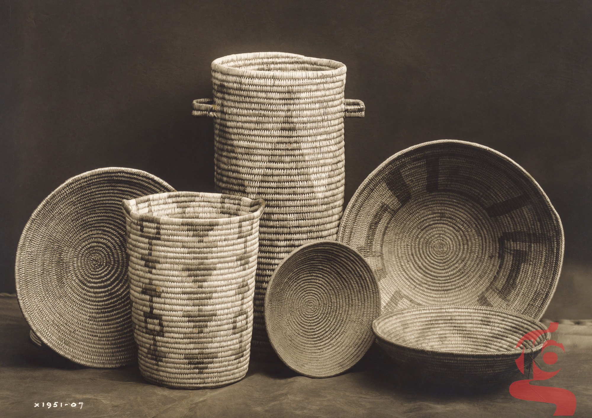 Assortiment de paniers et récipients en vannerie apache photographié par Edward S. Curtis en 1907.