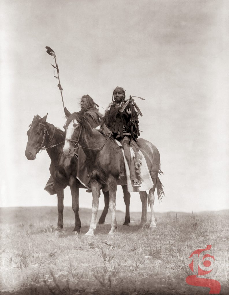 Deux cavaliers Apsaroke Crow à cheval sur la prairie du Montana, photographiés par Edward S. Curtis en 1908.